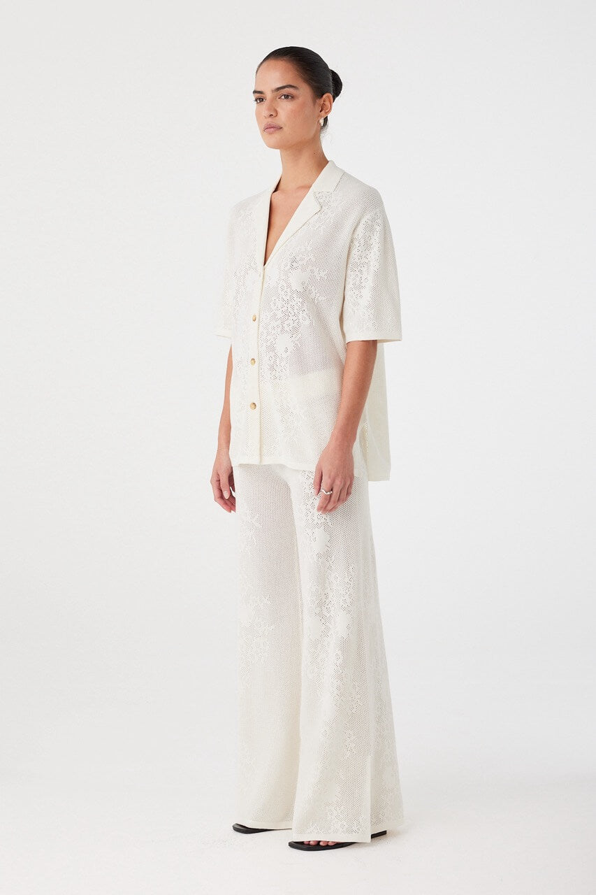 Side angle of cream crochet pants showing natural drape and soft waistband. Ideal for lightweight layering in warm weather.