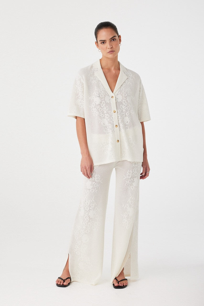 Model wearing matching crochet set with full-length pants. Fluid, breathable shape crafted for elevated warm-weather dressing.