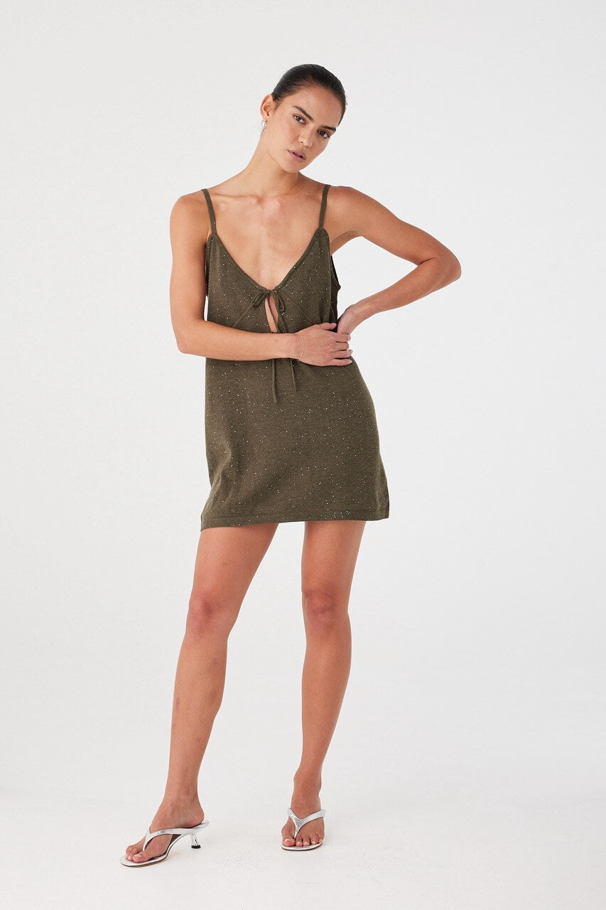 Mini dress in olive green shimmer knit, styled with white sandals. Lightweight and semi-fitted with soft sparkle finish.