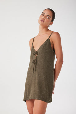 Model in linen cotton mini dress with subtle shine, styled effortlessly. V neckline and gentle shaping in a breathable textured knit.