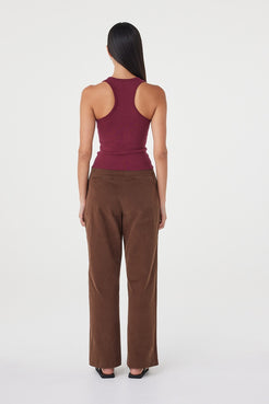 Back view of the Avery Pant in espresso featuring a soft velvet finish, clean waistband and relaxed straight-leg silhouette, styled with a fitted merlot ribbed tank and black sandals