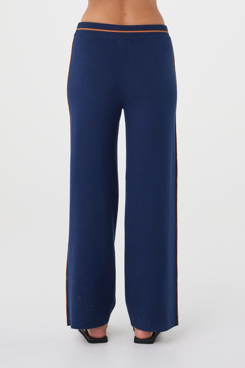 Back view of the Milan Pant in Navy & Tumeric featuring a clean finish, relaxed fit and contrast side stripe detailing.