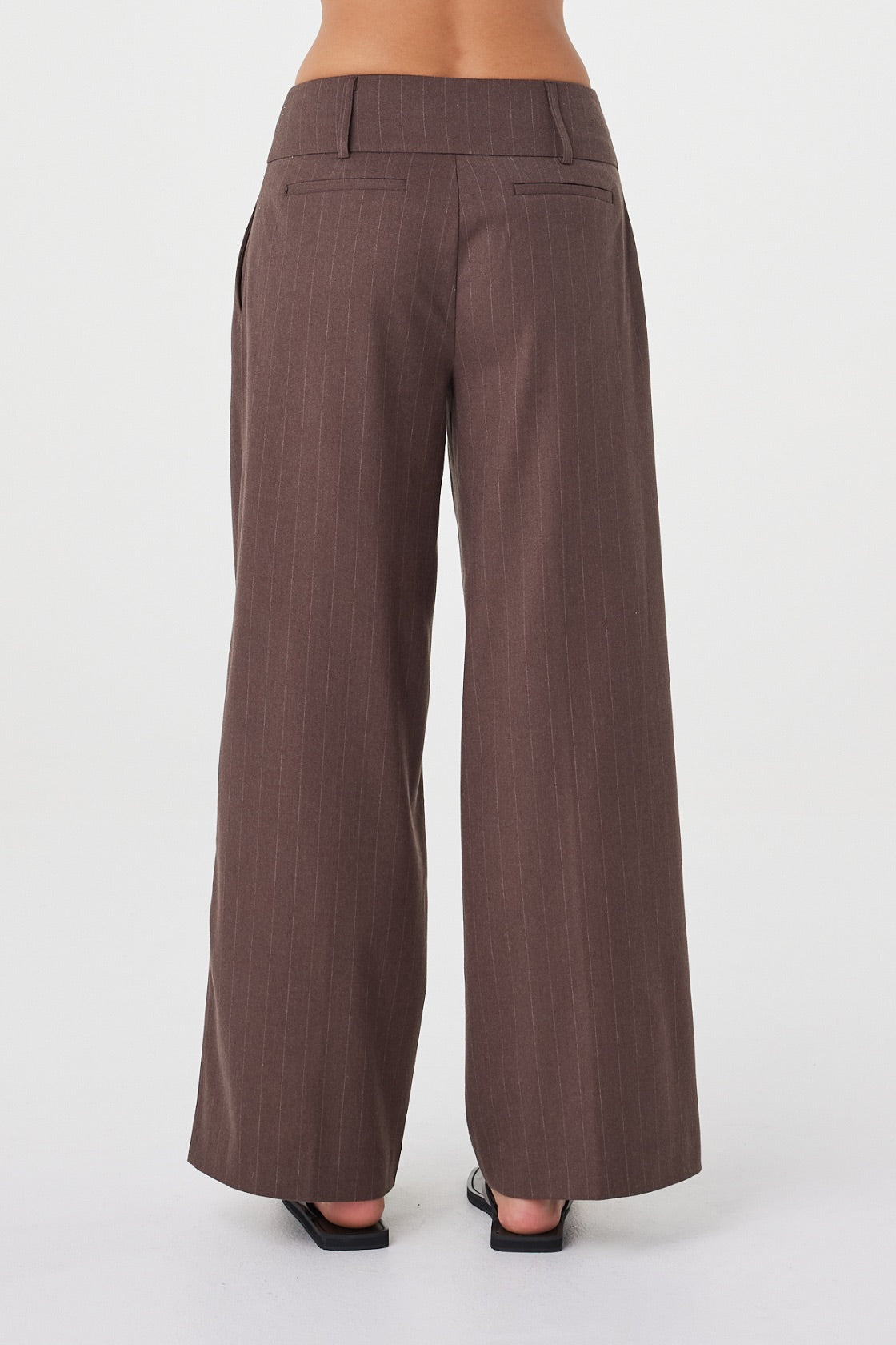 Back view of the Manon Pant in Espresso Pinstripe featuring the wide-leg fit and non-functional back welt pockets.
