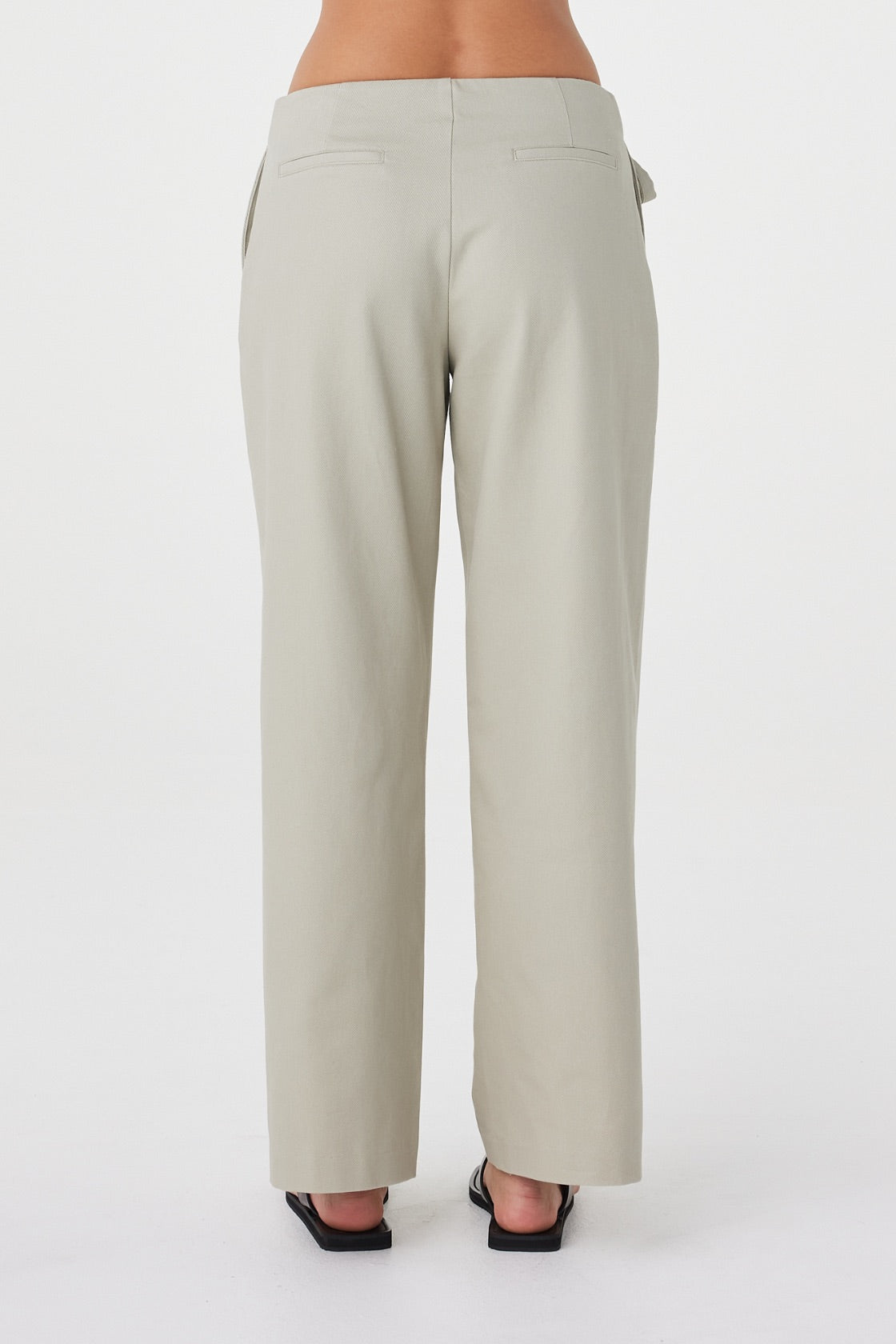 Back view of the Lucia Tie Pant in Light Sage featuring the clean back finish, non-functional welt pockets and relaxed fit.