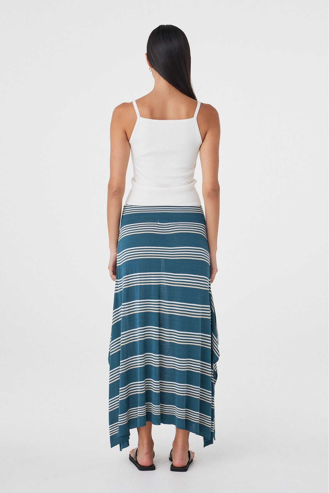 Back view of the Lex Skirt in Teal Stripe featuring the elasticated waistband, longline silhouette and asymmetric handkerchief hem.