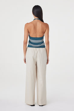 Back view of the Annika Pant in Taupe styled with a striped tank, showing the clean waistband finish and relaxed drape.
