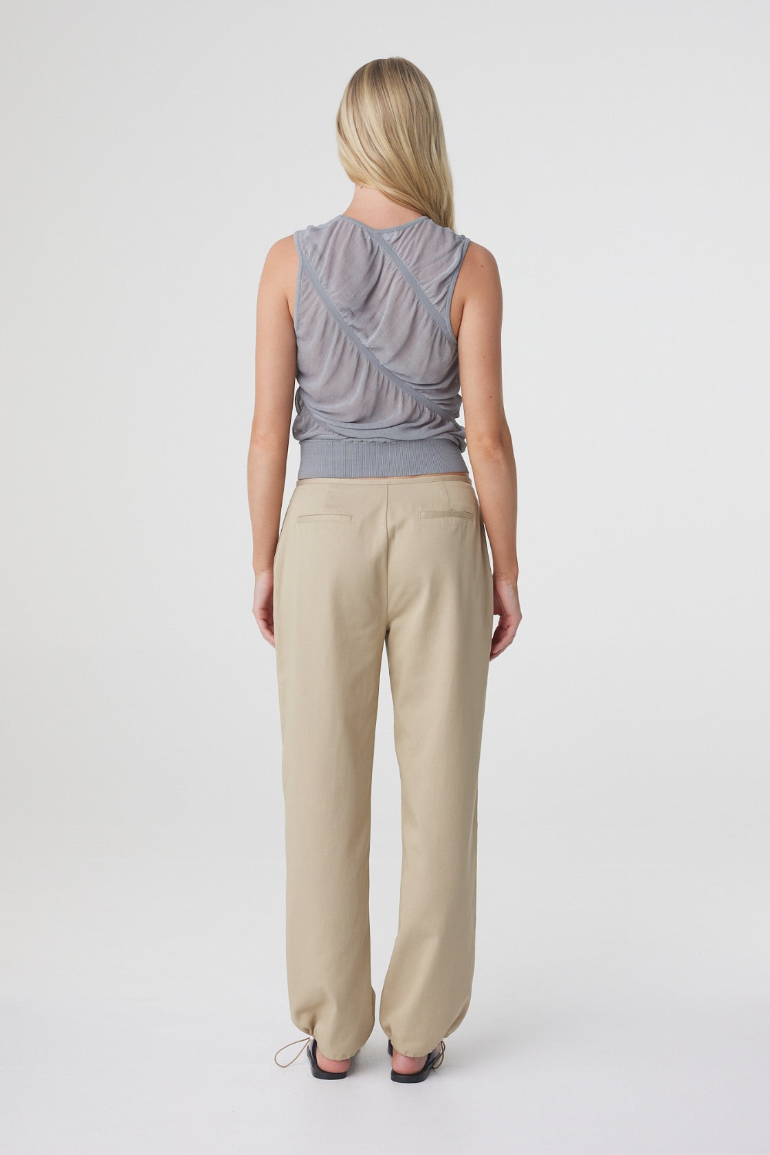 Sabi Pant in Taupe styled with a grey sleeveless top, back view showing the fit through the hips and straight leg silhouette.