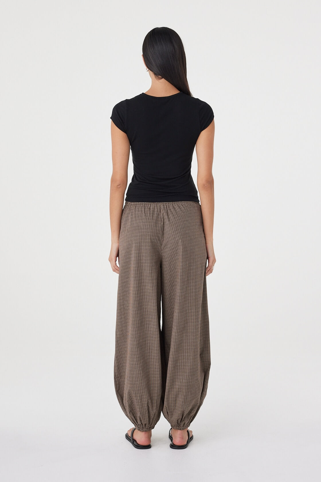 Back view of the Elina Balloon Pant in Chocolate Check featuring the elasticated back waistband, gathered volume and relaxed fit.