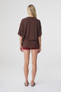 Tove Short in Chilli, back view styled with an oversized espresso tee, showing the fitted silhouette through the waist and hips.