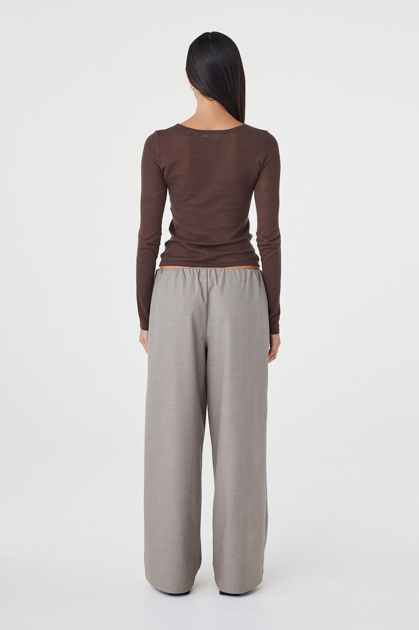 Back view of the Annika Pant in taupe blue pinstripe paired with a fitted brown long sleeve top, highlighting the relaxed fit and fluid movement through the leg