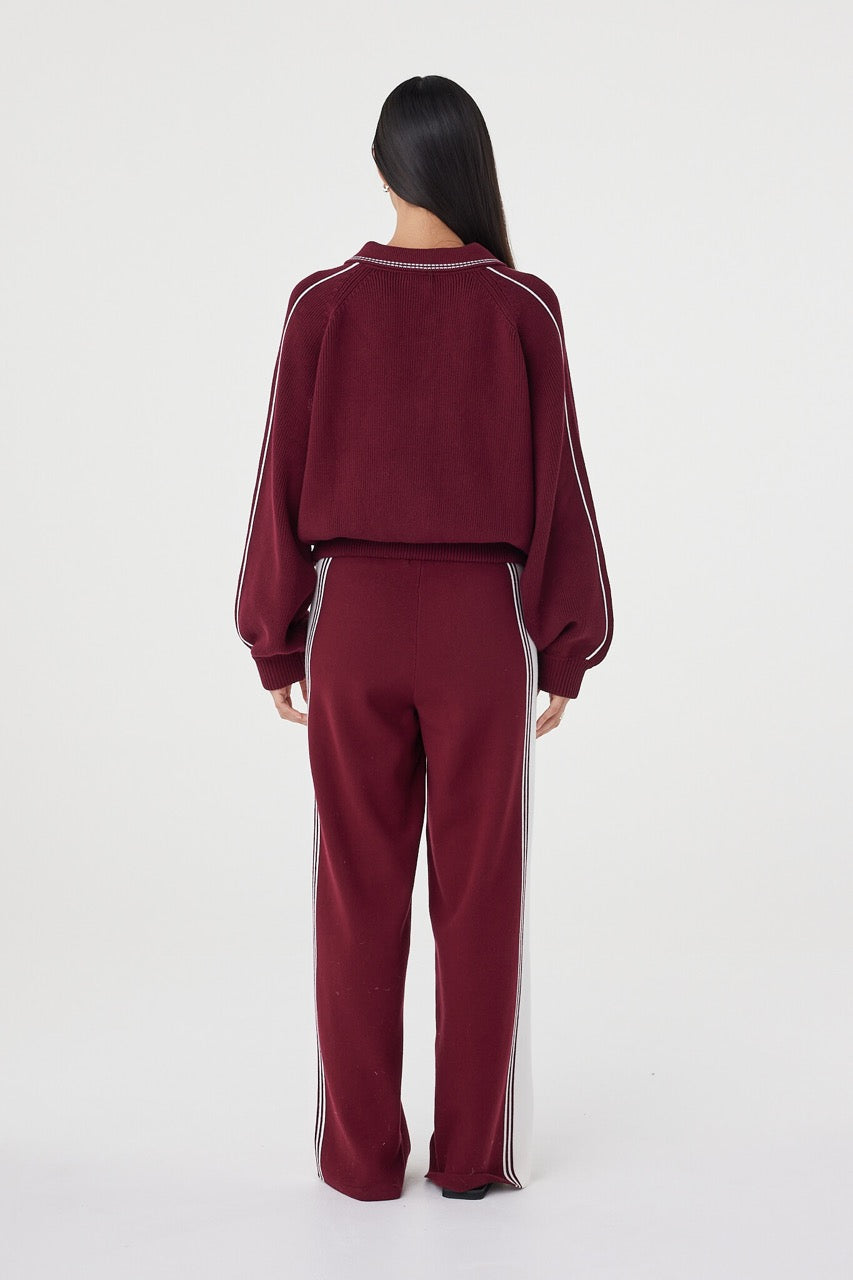 Back view of the Nella Zip in merlot and cream showcasing the relaxed silhouette, ribbed waistband and contrast cream piping running along the sleeves