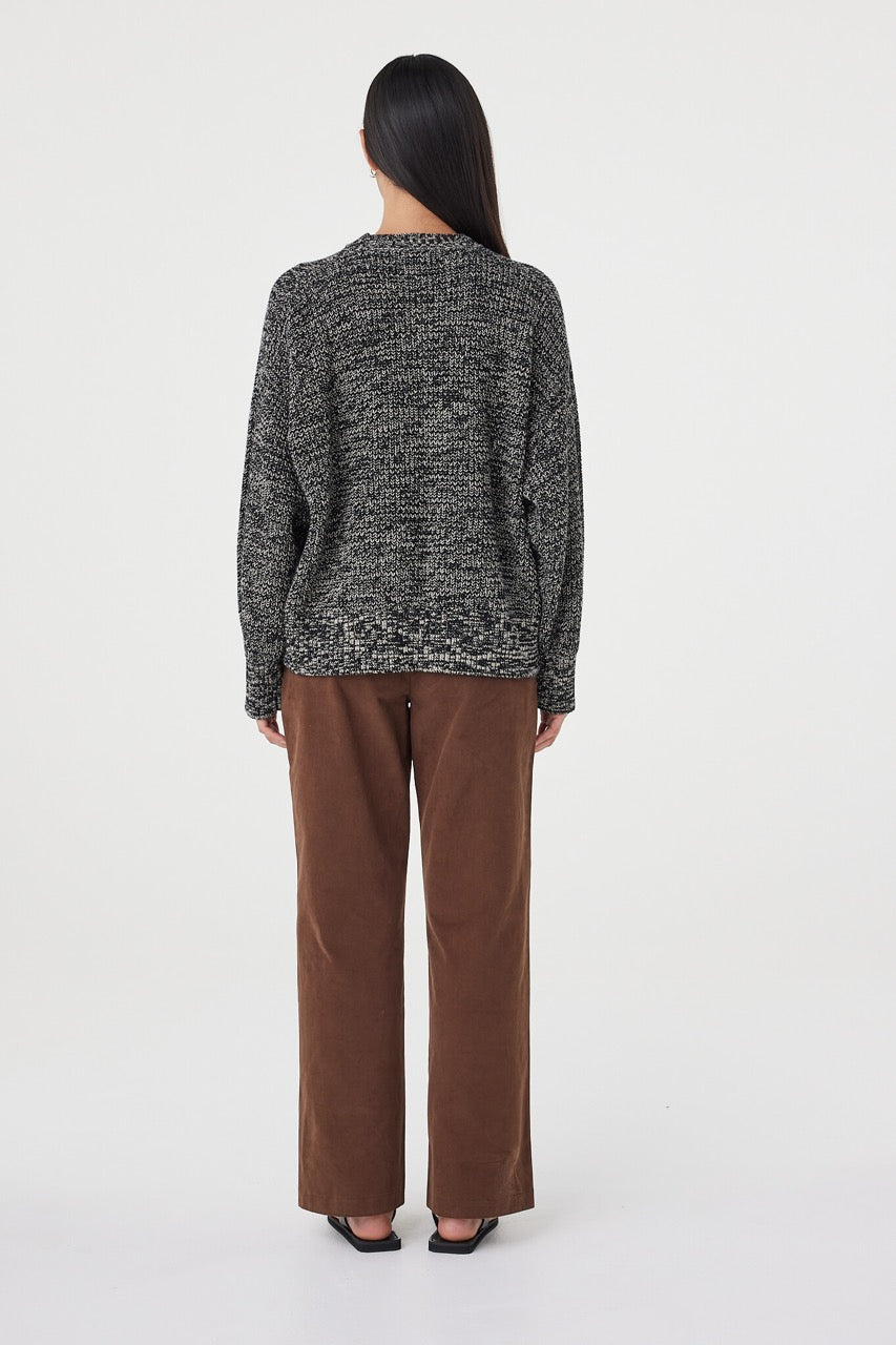 Back view of the Solene Sweater in black and taupe showcasing the relaxed fit through the body, raglan sleeve construction and textured mottled knit finish