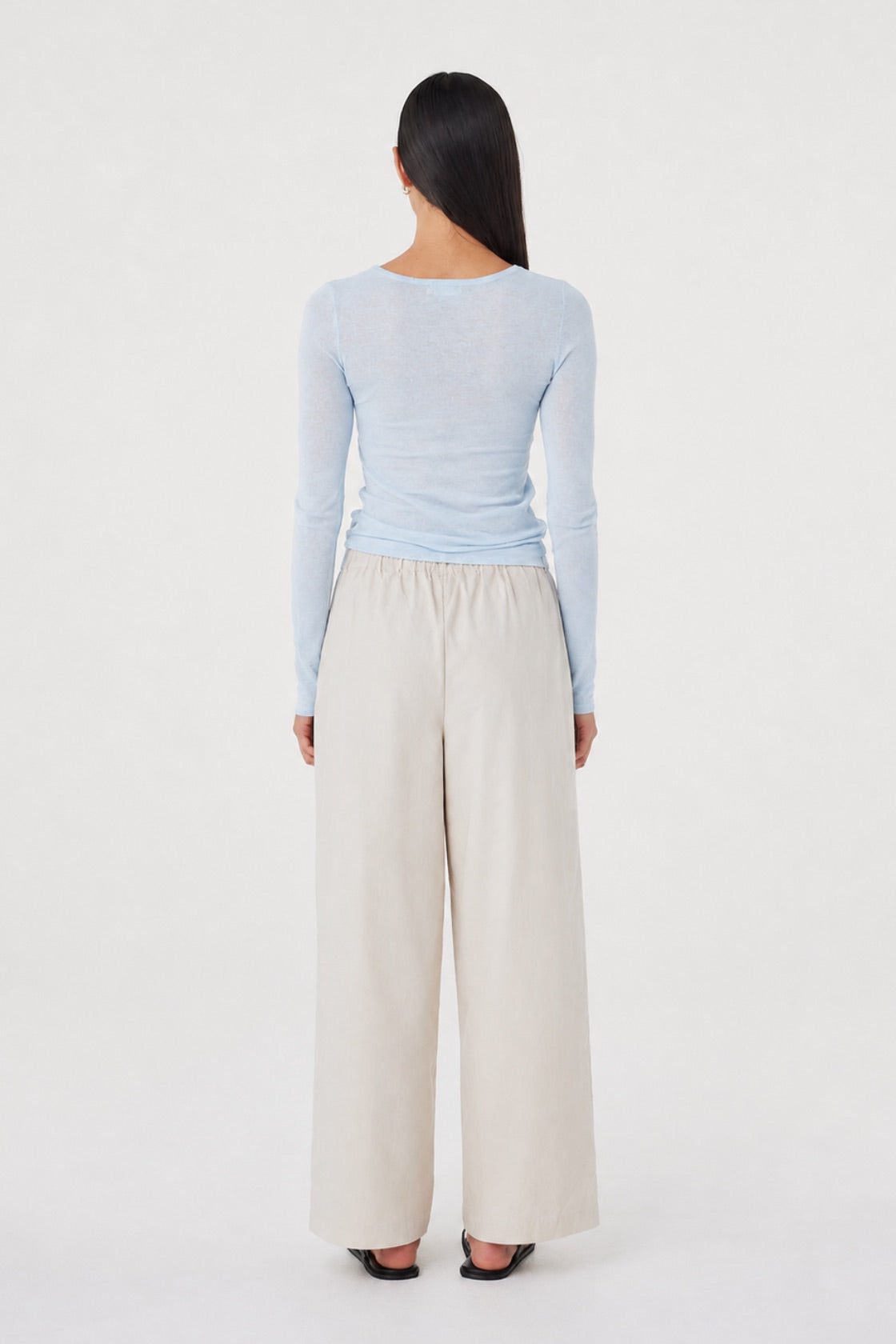 Aston LS Top in Pale Blue styled with the Annika Pants in Taupe, full-length back view showing the clean back neckline and slim fit through the body.