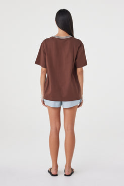 Kylen Tee in Espresso & Cream styled with pale blue shorts, full-length back view showing the relaxed fit and longer hem.