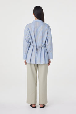 Back view of the Blair Shirt in Blue Taupe Stripe showcasing the adjustable waist tie, relaxed silhouette and vertical stripe detailing.