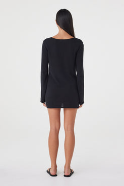 Back view of the Kira Mini Dress in Black featuring a clean mini silhouette, boat neckline and long sleeves.