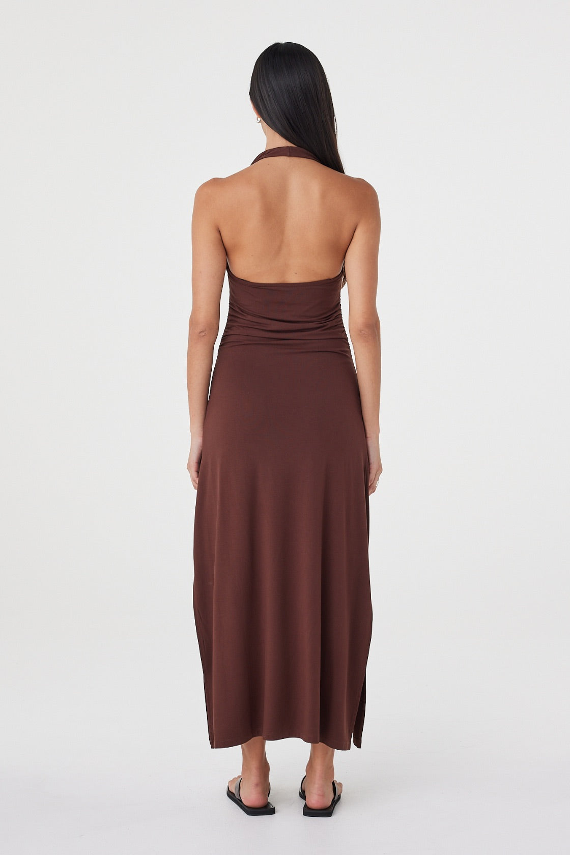 Back view of the Suki Dress in Espresso showing the open halter back, fitted waist and fluid maxi-length skirt.