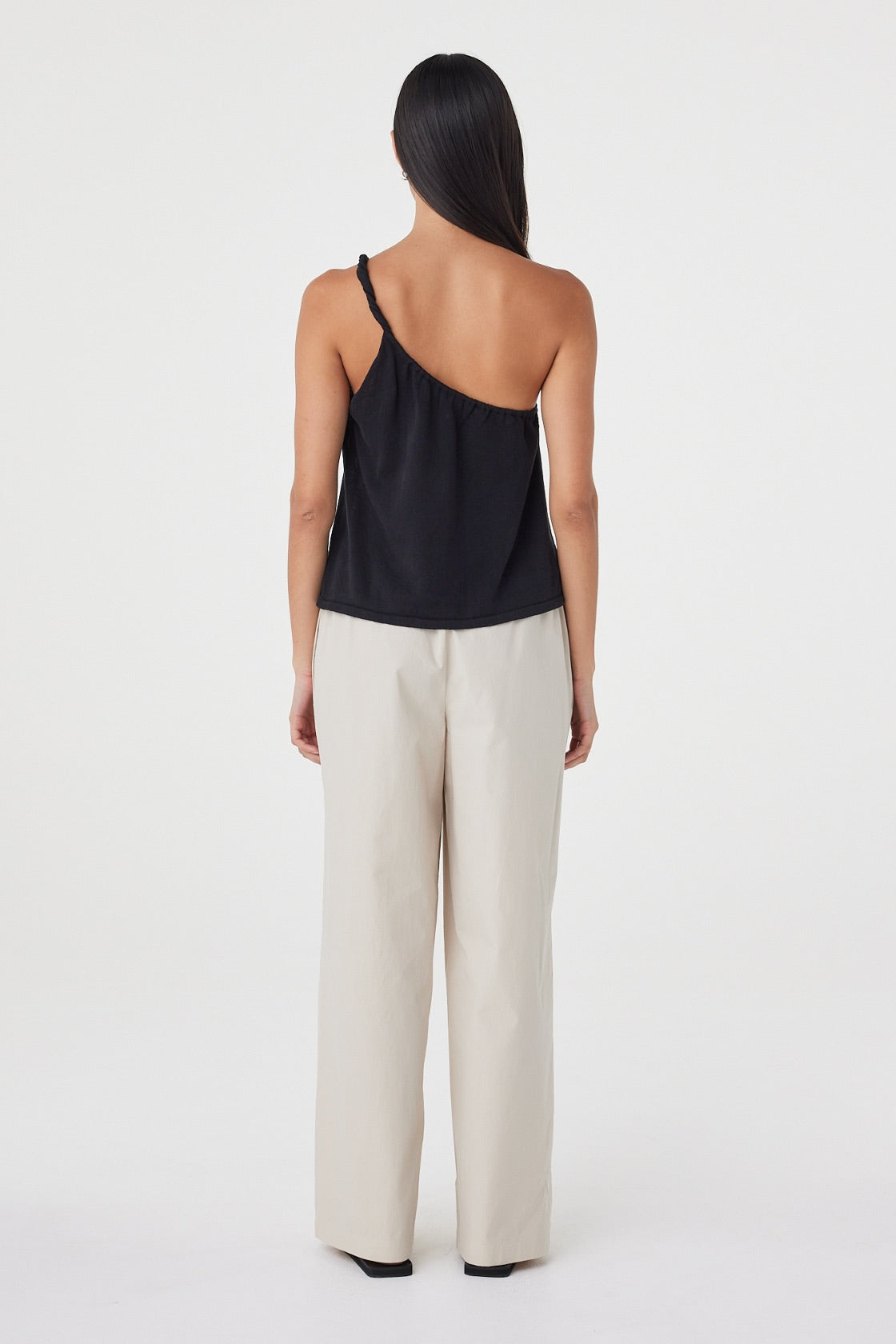 Back view of the Harri Asym Top in Black featuring the asymmetric shoulder line and relaxed silhouette through the body.