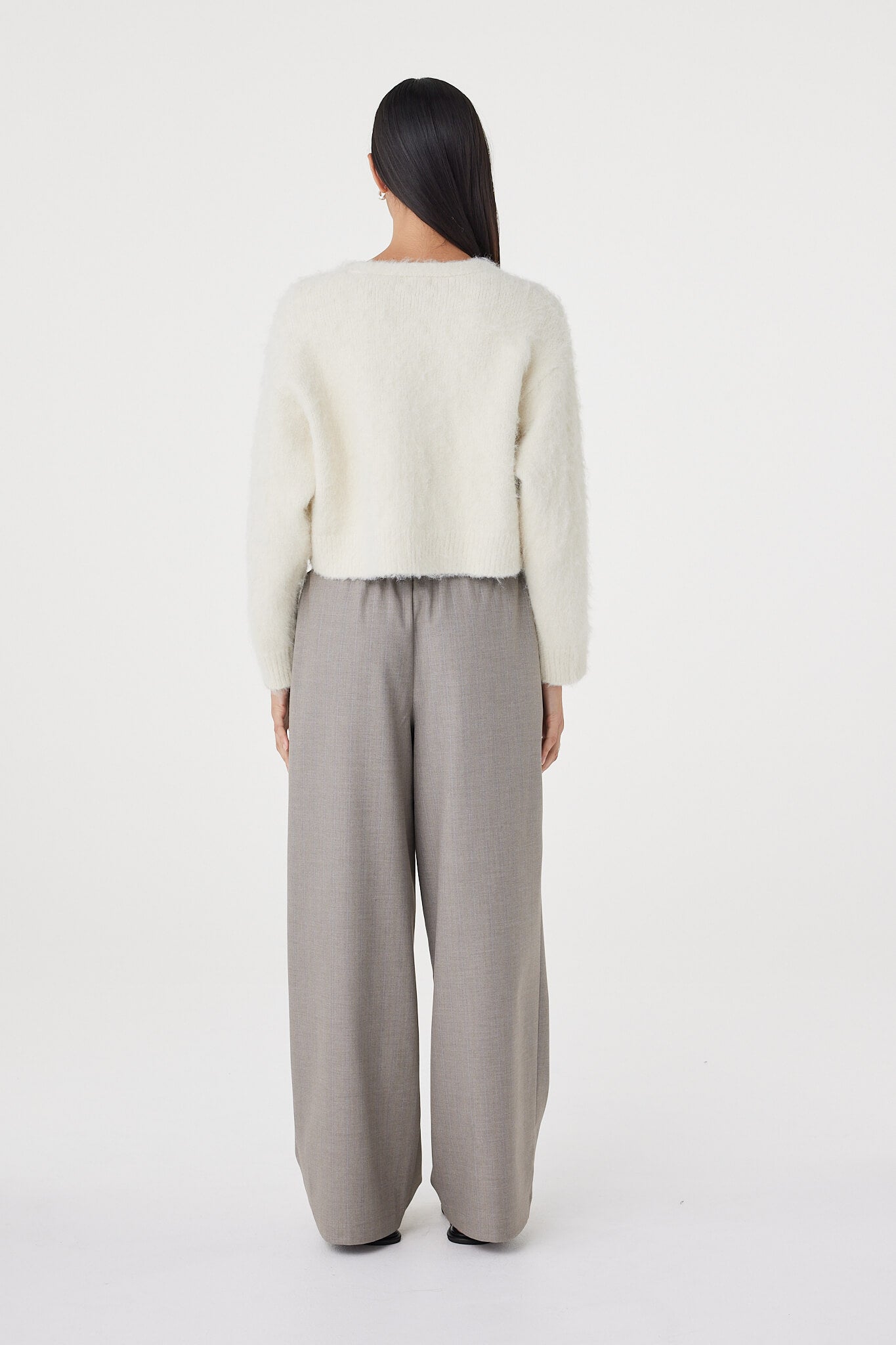 Back view of the Liora Fluffy Cardigan in cream showcasing the relaxed cropped fit, ribbed hemline and soft brushed knit finish through the body and sleeves