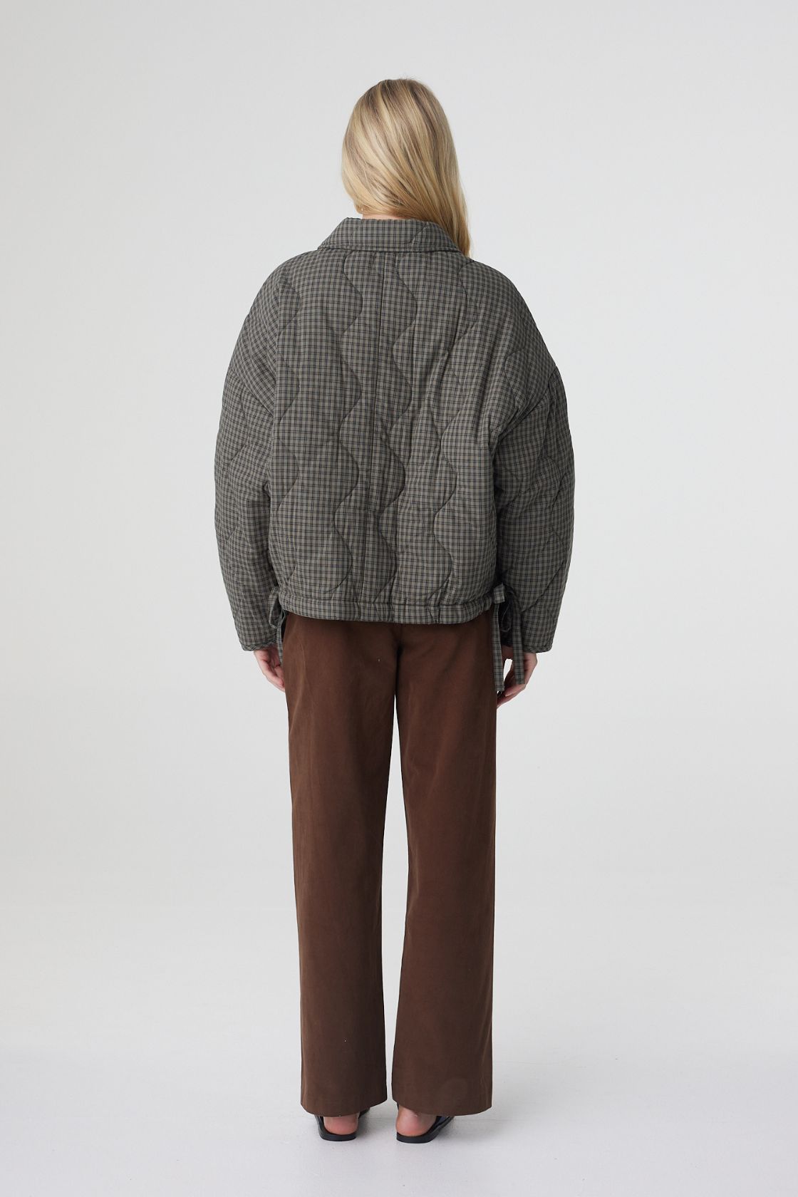 Back view of the Matteo jacket in olive and teal check, showcasing the quilted check pattern, dropped shoulders and relaxed volume through the body.