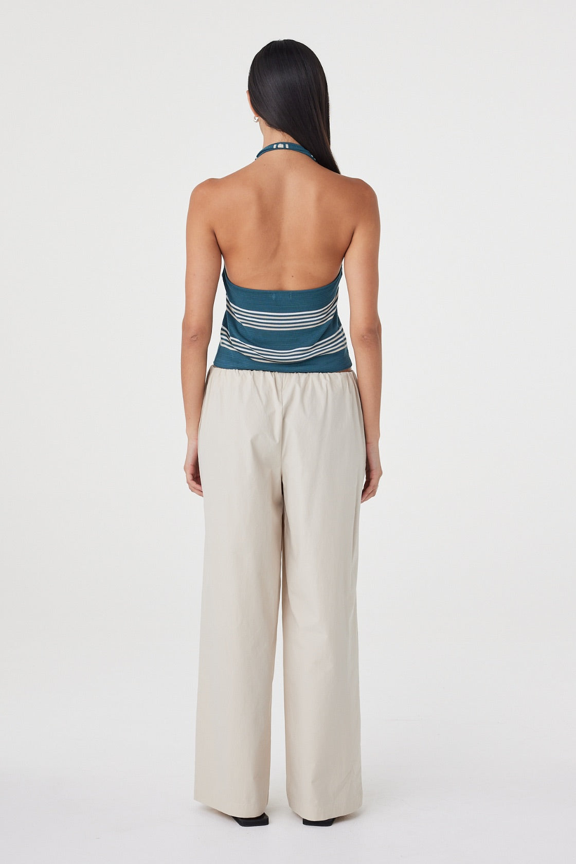 Back view of the Nuri Top in Teal Stripe showing the open-back halter silhouette and custom striped knit.