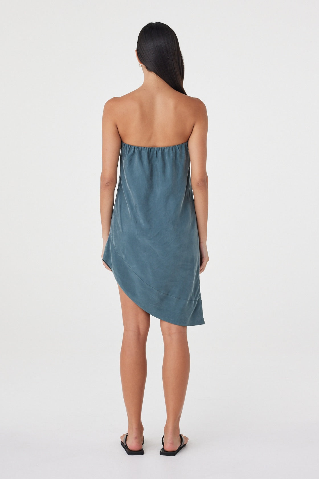 Back view of the Rhea Dress in Teal highlighting the strapless back, elasticated construction and fluid hemline.