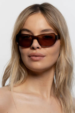 Lifestyle shot featuring coffee brown sunglasses with lightweight fit and vintage inspired silhouette