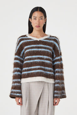 Front view of the Lucca Sweater in Espresso & Blue Stripe featuring a fluffy knit texture, relaxed silhouette and soft blue stripe detailing, styled with light taupe wide-leg trousers.
