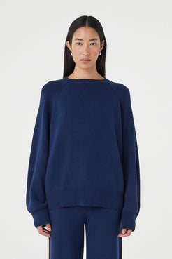 Front view of the Aubrey Sweater in Navy featuring a relaxed silhouette, fine knit texture and gathered neckline detailing, styled with matching navy knit pants.