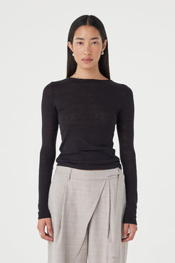 Front view of the Aston LS in Black featuring a fitted silhouette, lightweight stretch fabrication and clean boat neckline, styled with light taupe wrap-detail trousers.