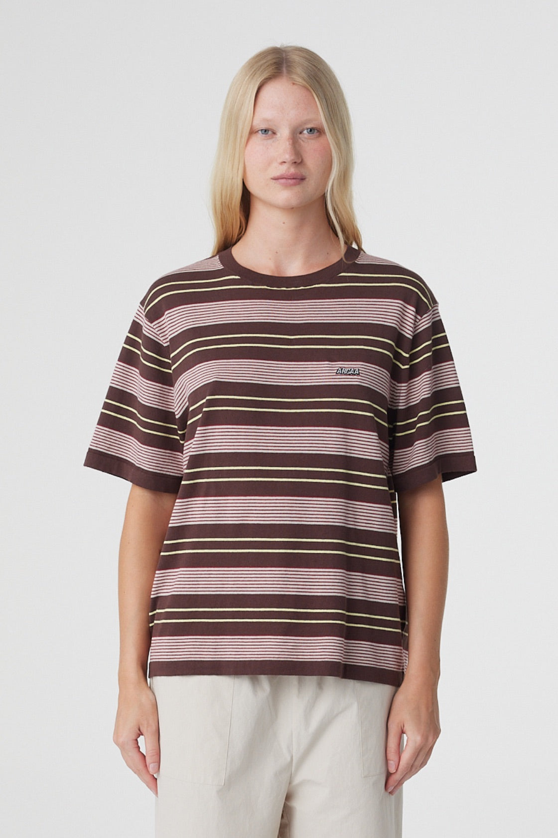 Noor Tee in Red & Brown Retro Stripe, close front view showing the relaxed fit, ribbed crew neckline and Arcaa logo at the chest.