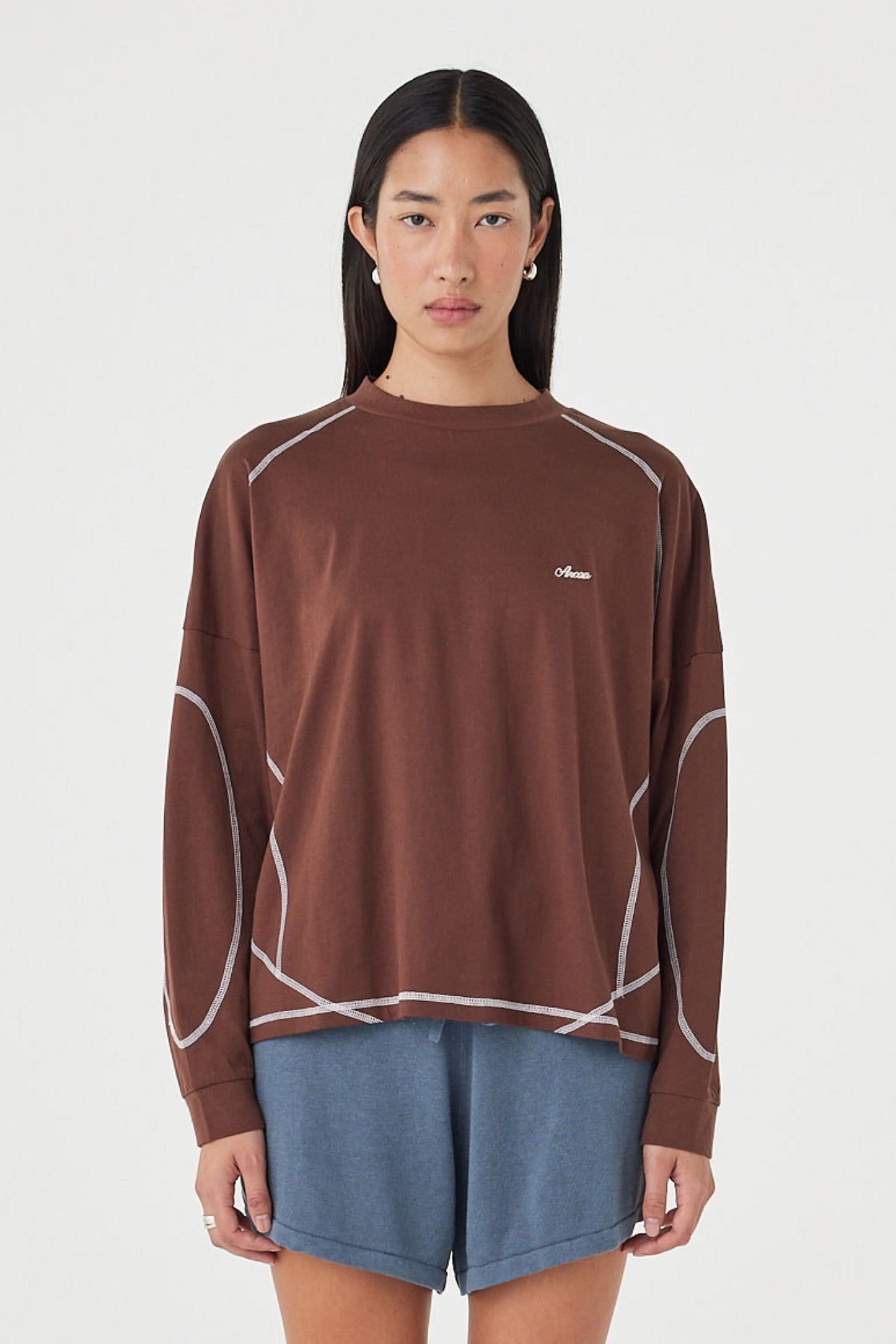 Front view of the Kesh LS Tee in Espresso & Cream featuring contrast overlocking, a relaxed silhouette and dropped shoulders, styled with blue lounge shorts.
