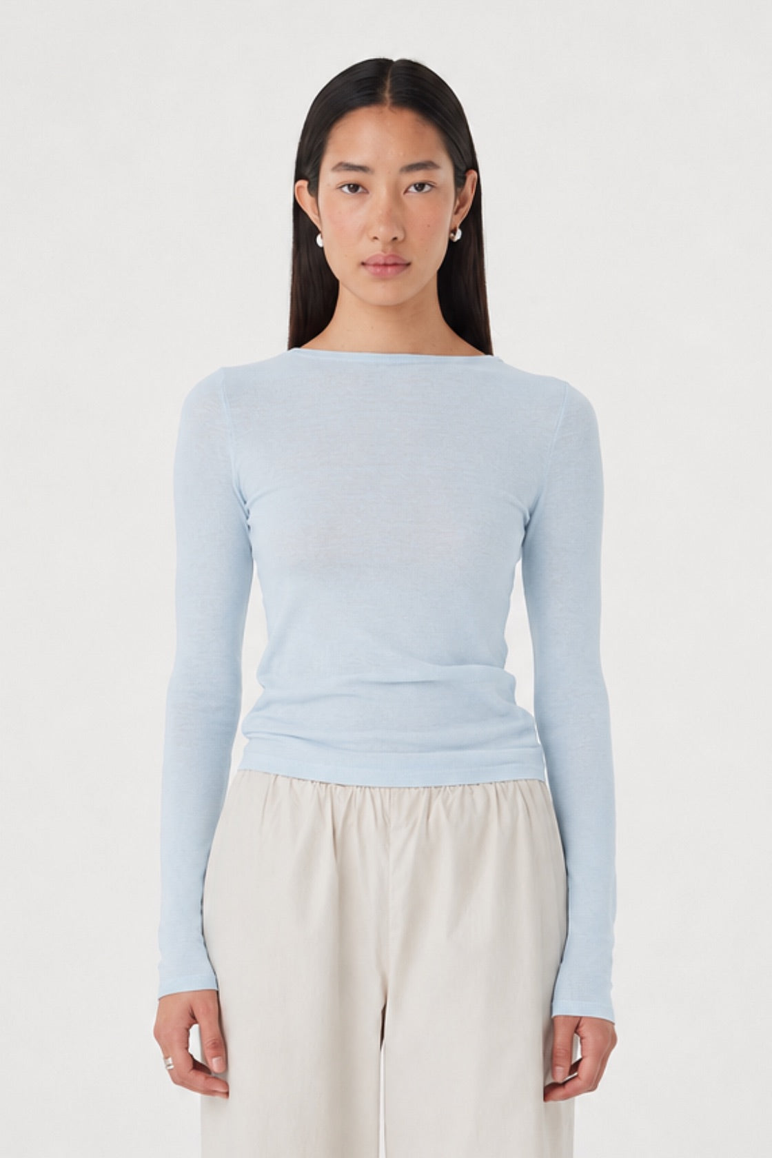 Aston LS Top in Pale Blue styled with the Annika Pants in Taupe, close front view showing the slim fit, boat neckline and long sleeves.