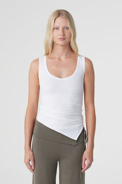 Elin Tank in Cream, close front view highlighting the deep scoop neckline, fitted shape, side ruching and asymmetrical hem. 