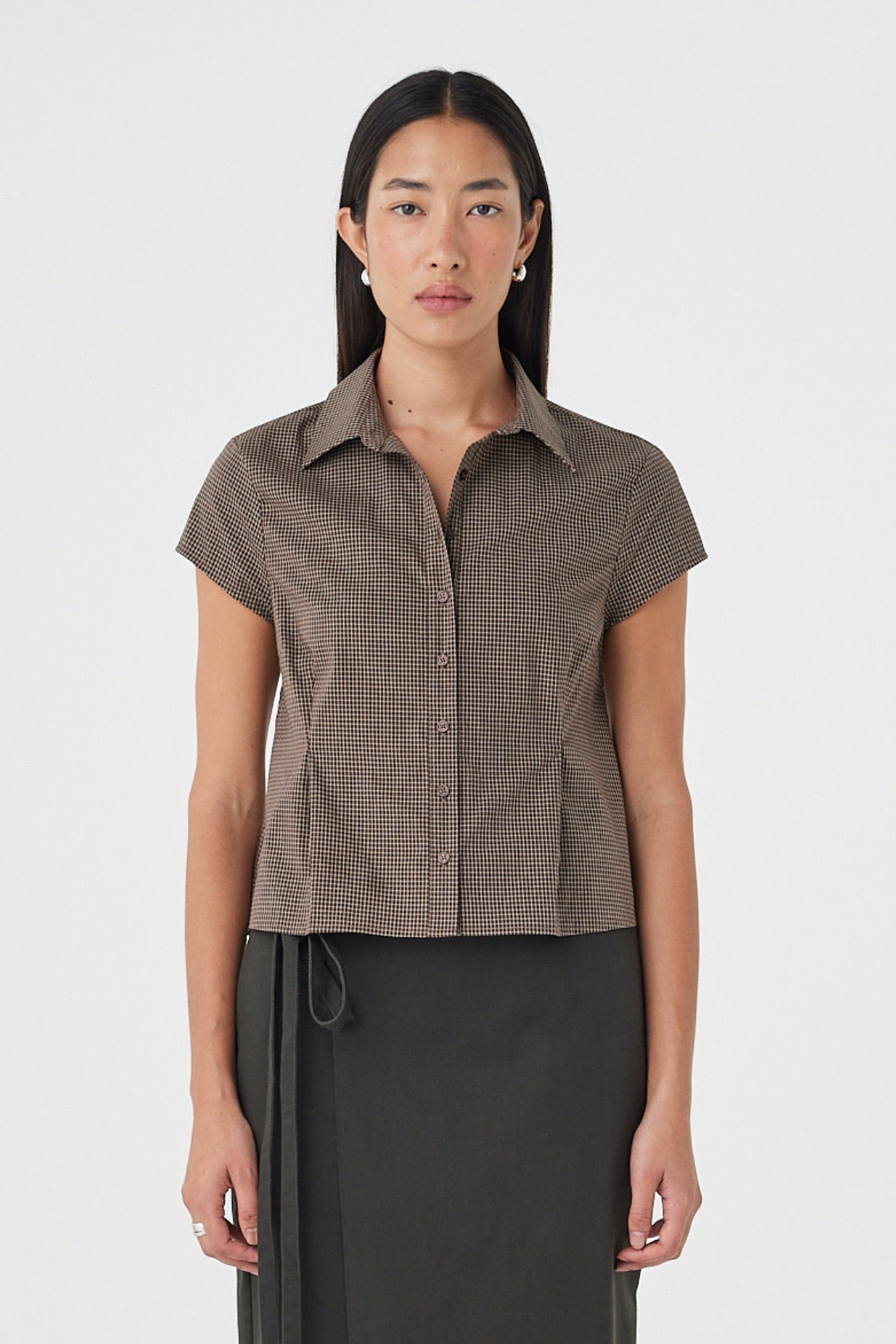 Front view of the Freya Shirt in Chocolate Check featuring a fitted silhouette, cap sleeves, classic collar and button-front closure, styled with a charcoal midi skirt.