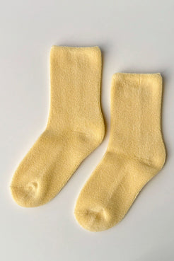 Pair of lemon yellow socks laid flat showing crew length and texture