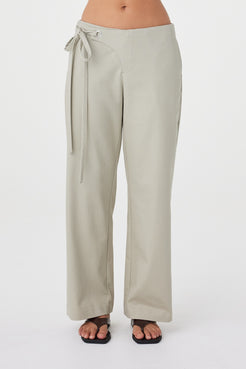 Front detail view of the Lucia Tie Pant in Light Sage showcasing the concealed zip closure, fabric overlap detail and adjustable waist ties.