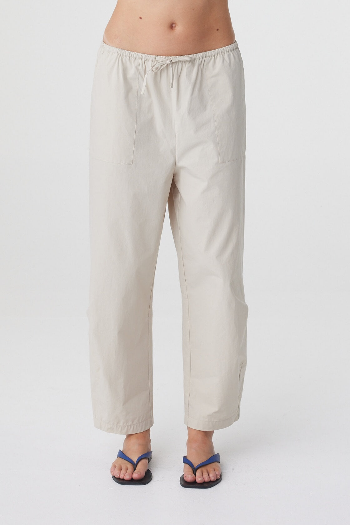Lena Barrel Pant in Taupe, close front view highlighting the elasticated drawstring waistband, patch pockets and curved leg shape.