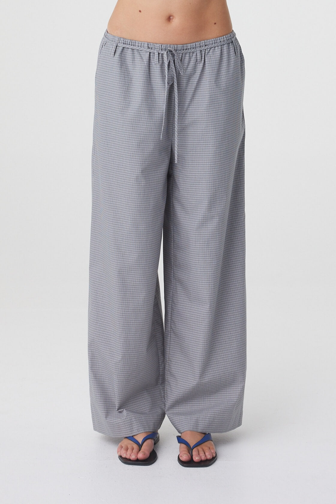 Sia Pant in Muted Blue Check, close front view showing the mid rise elasticated waistband, tie detail and wide leg shape.