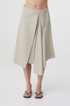 Anya Skirt in Taupe, close front view highlighting the deep waistband, wrap construction, tie detail and asymmetric hemline.