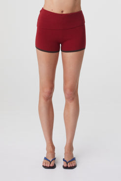 Tove Short in Chilli, close front view highlighting the mid rise fit, fold over waistband and fitted shape through the hips.