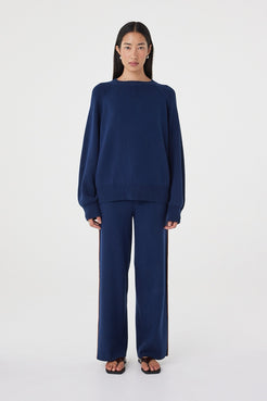 Front view of the Milan Pant in Navy & Tumeric featuring a relaxed wide-leg silhouette, contrast side stripes and drawcord waistband, styled with the matching Aubrey Sweater.
