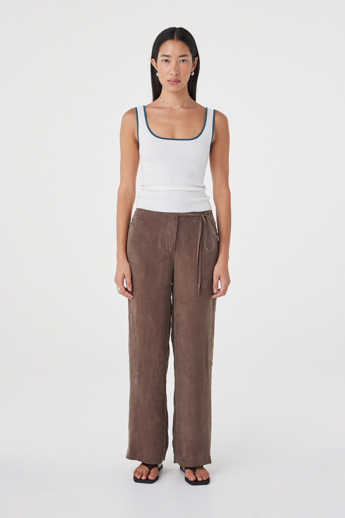 Front full-length view of the Maisie Tie Pant in Espresso featuring a mid-rise waist, side tie detailing and relaxed straight-leg silhouette, styled with a cream tank.