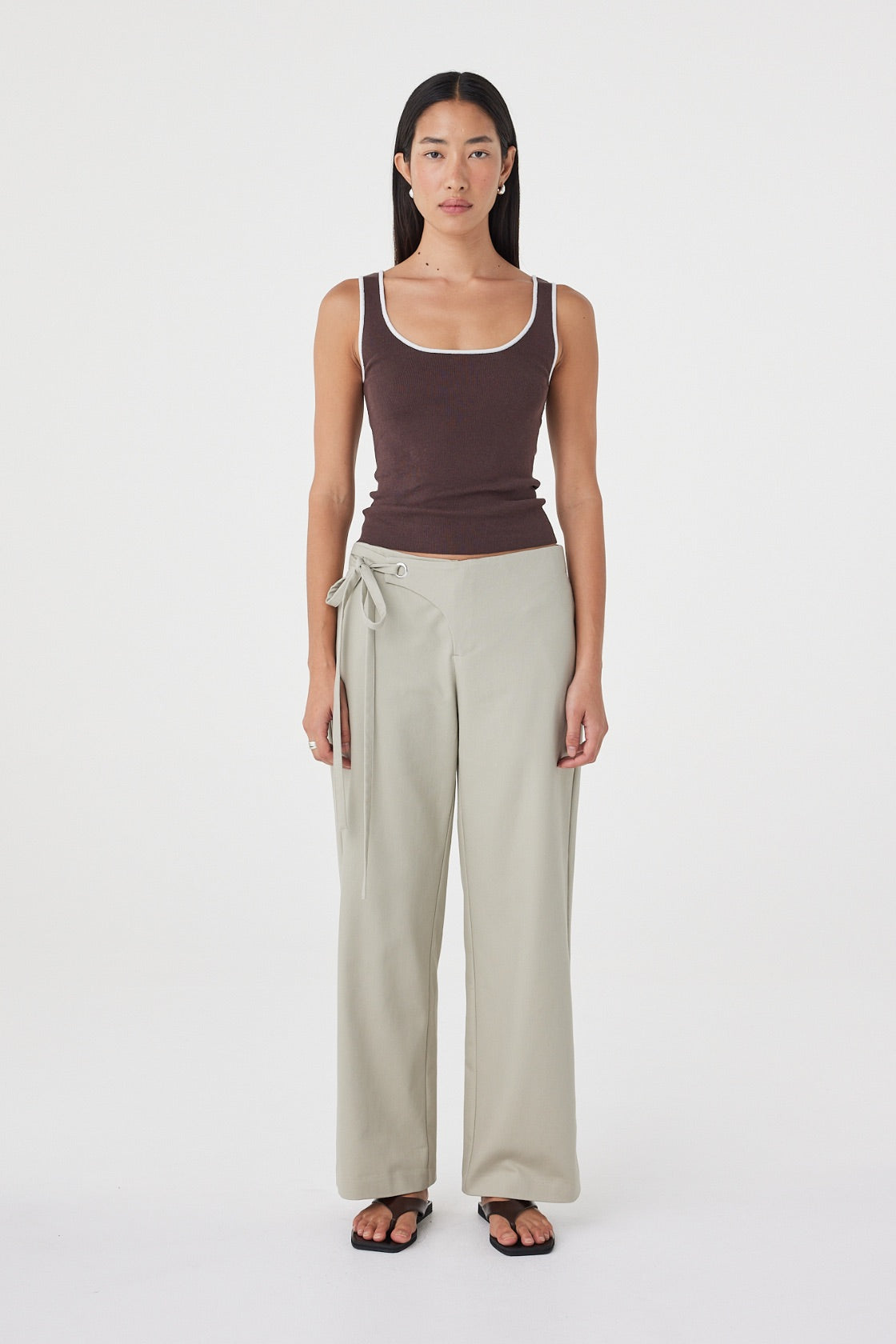 Front view of the Lucia Tie Pant in Light Sage featuring adjustable double waist ties, a relaxed straight-leg silhouette and soft cotton fabrication, styled with an espresso tank.