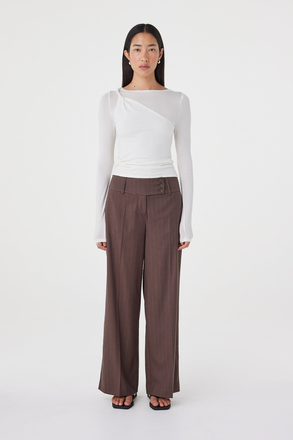 Front view of the Manon Pant in Espresso Pinstripe featuring a tailored wide-leg silhouette, three-button waistband and soft structured fabrication, styled with a white fitted top.