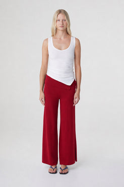 Nora Pant in Chilli, full front view styled with a white tank, showing the wide leg silhouette and asymmetrical fold over waistband.