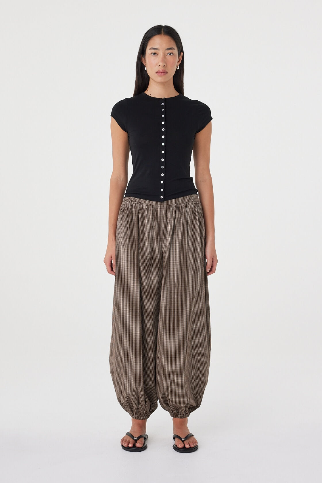 Front view of the Elina Balloon Pant in Chocolate Check featuring a relaxed balloon-leg silhouette, gathered hems and subtle micro check fabrication, styled with the Robbie Top in Black.