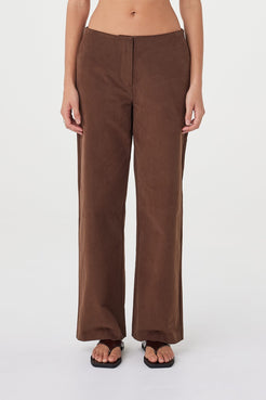 Close-up front view of the Avery Pant in espresso showcasing the velvet finish, minimal waist detailing and relaxed straight-leg fit, styled with dark brown sandals