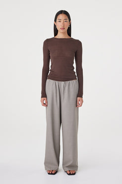 Front view of the Annika Pant in taupe blue pinstripe styled with a fitted espresso brown long sleeve top and black sandals, featuring a relaxed wide-leg silhouette and soft elasticated waistband
