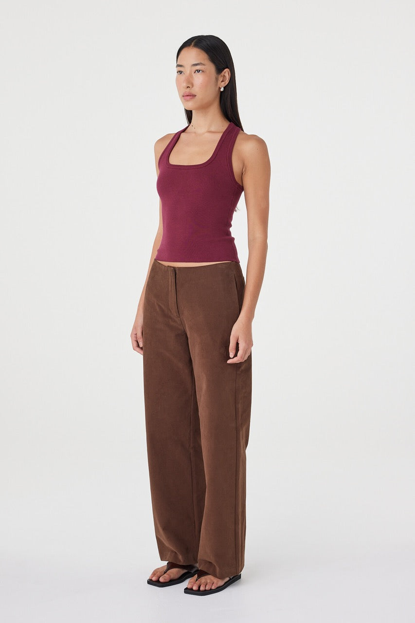 Side profile view of the Sable Top in merlot paired with espresso tailored pants and black sandals, highlighting the racerback shape and close fit through the body